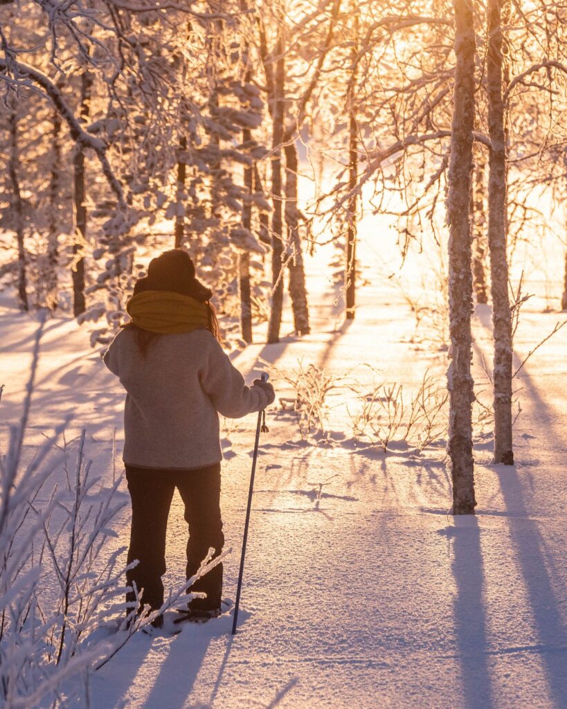 Person snowshoeing through snowy forest in Finland